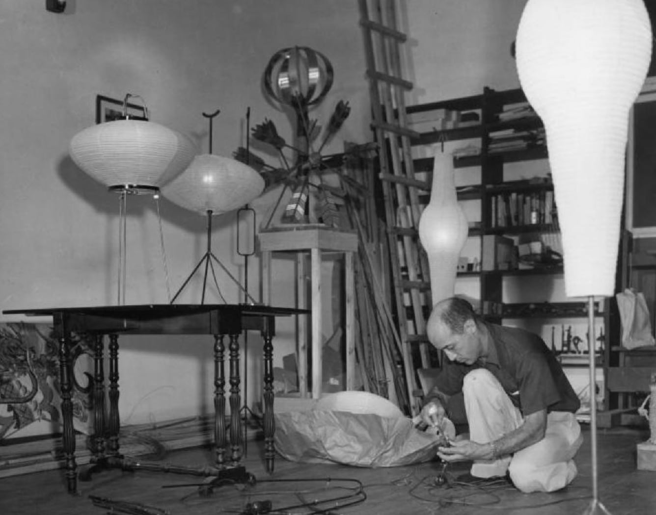 Photographie d’isamu noguchi travaillant sur des prototypes d’akari, vers 1951